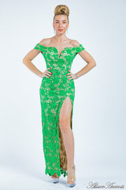 Woman wearing a green lace dress with a front slit. 