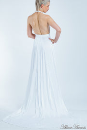 Woman showing a white silk satin halter neck gown is backless.