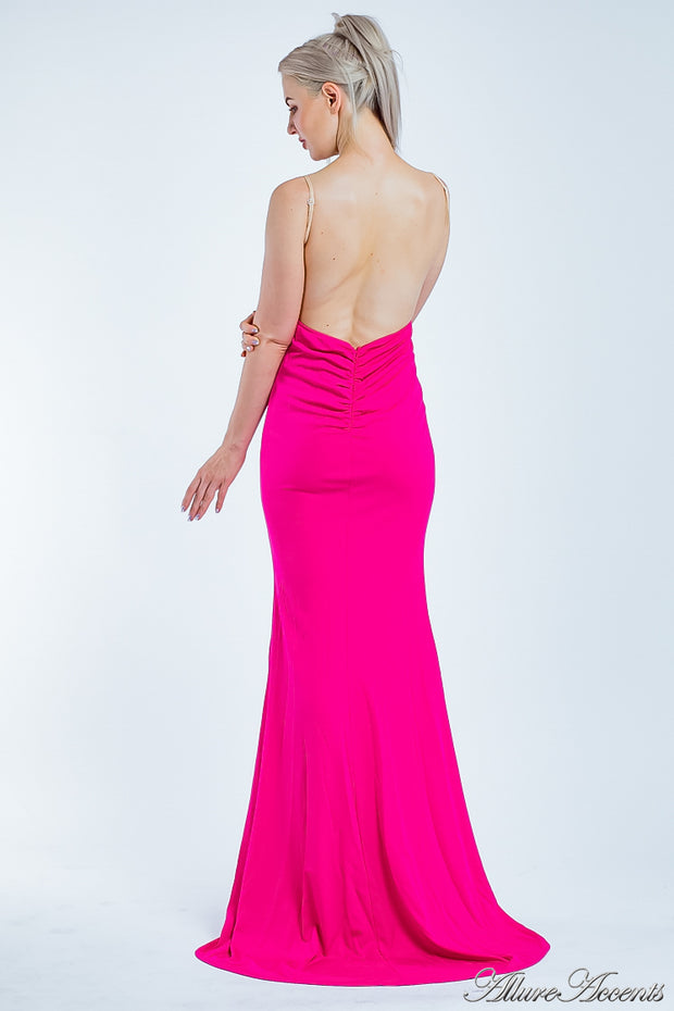 Woman showing her long hot pink gown is backless and has ruching on the butt. 