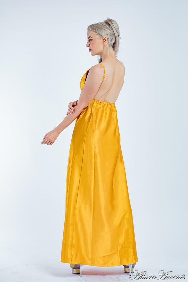 Woman wearing a  gold long satin dress showing it has a low back.
