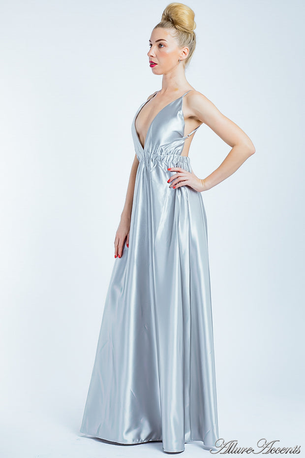Woman wearing a silver long satin dress that has a deep v neckline.