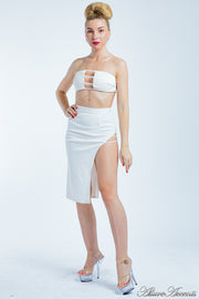 Woman is wearing a white 2 pieces summer party set, strapless top and sexy side slit skirt 