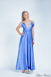 Woman wearing a royal blue long satin dress that has a deep v neckline.