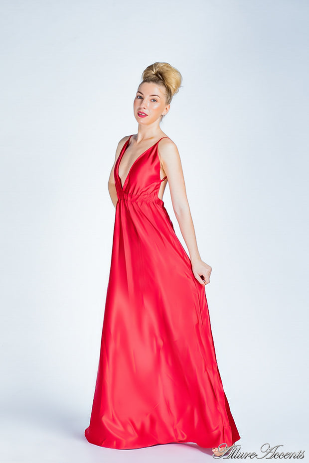 Woman wearing a red colored long satin dress that has a deep v neckline.