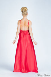 Woman wearing a red colored long satin dress showing it has a low back.
