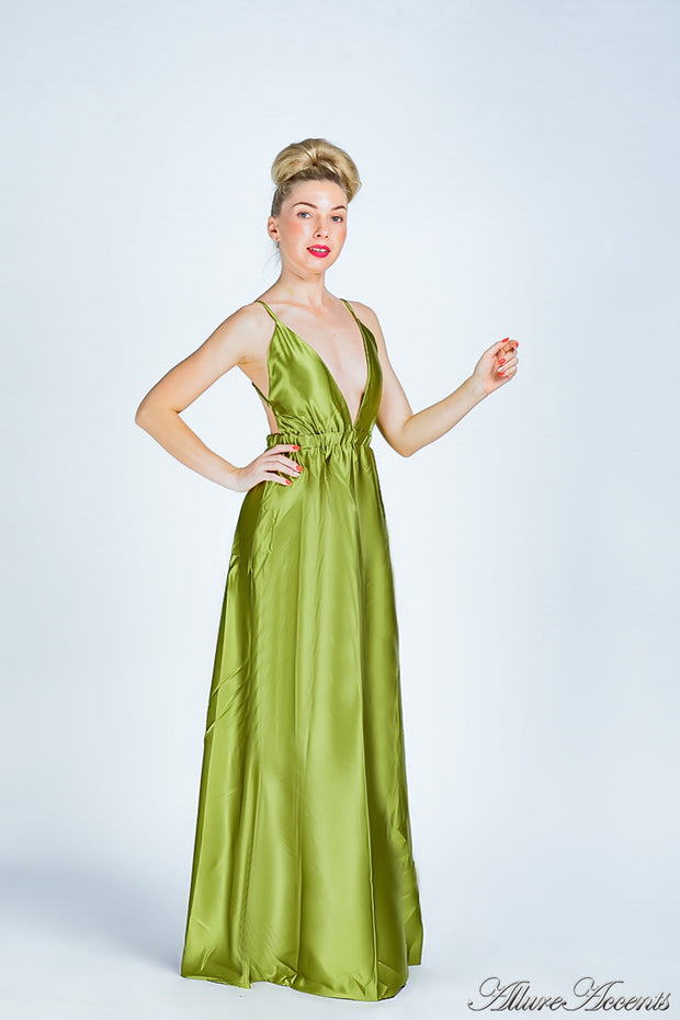 Woman wearing an olive green long satin dress that has a deep v neckline.