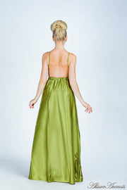 Woman wearing an olive green  long satin dress showing it has a low back.
