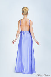 Woman wearing a periwinkle colored long satin dress showing it has a low back.