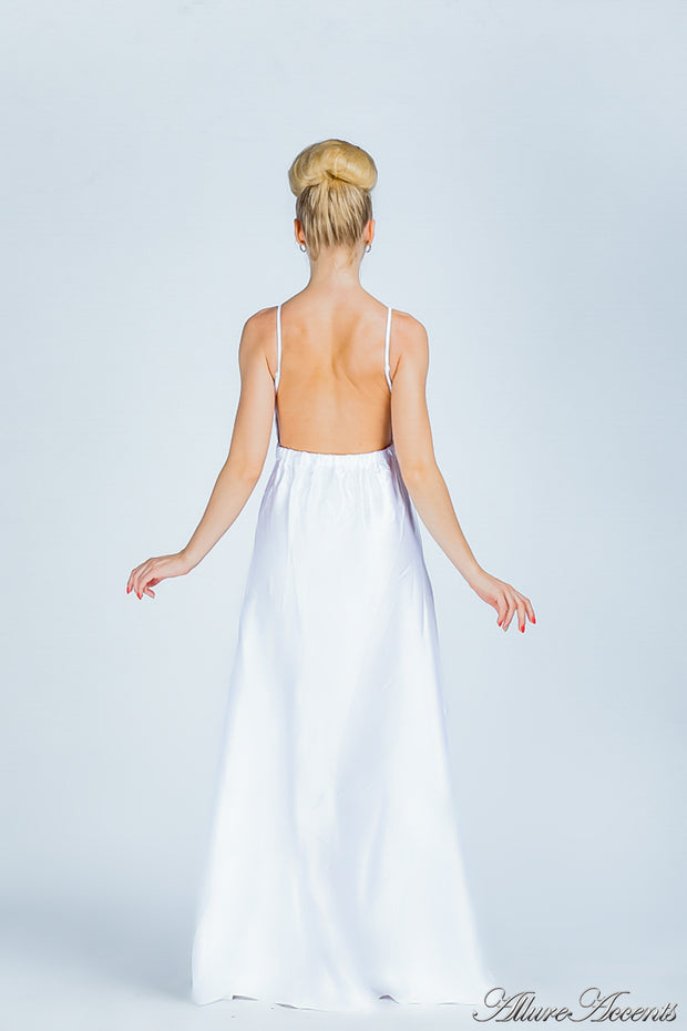 Woman wearing a white long satin dress showing it has a low back.