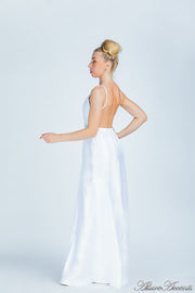 Woman wearing a white long satin dress that has a deep v neckline.