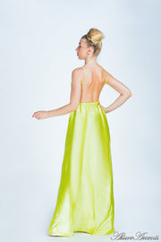 Woman wearing a lemon colored long satin dress showing it has a low back.