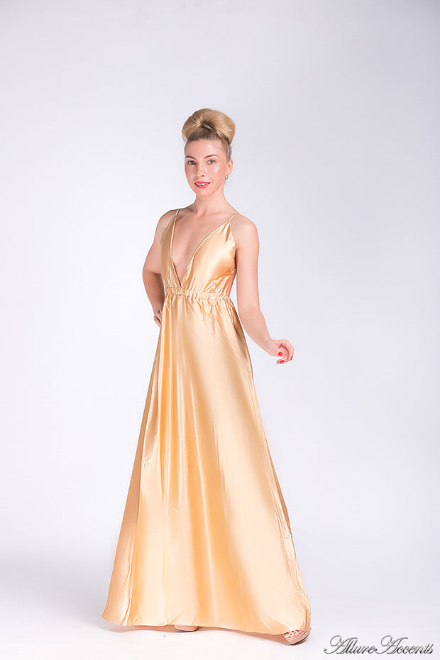 Woman wearing a champagne gold long satin dress that has a deep v neckline.