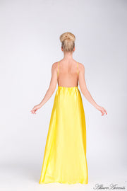 Woman wearing a yellow long satin dress showing it has a low back.