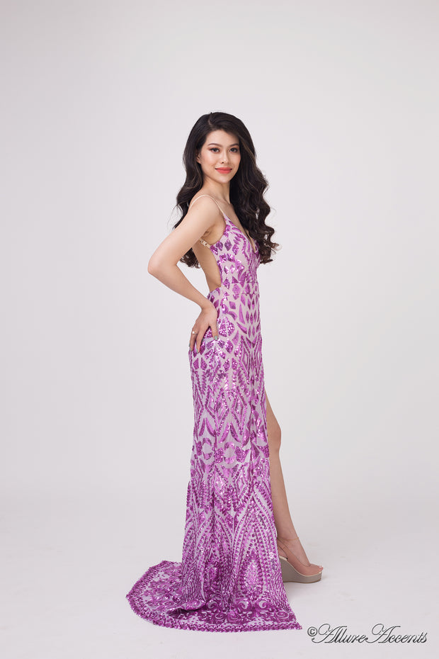 Woman wearing a long purple sequined dress with a high slit.