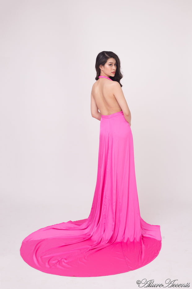 Woman showing a barbie pink silk satin halter neck gown is backless.