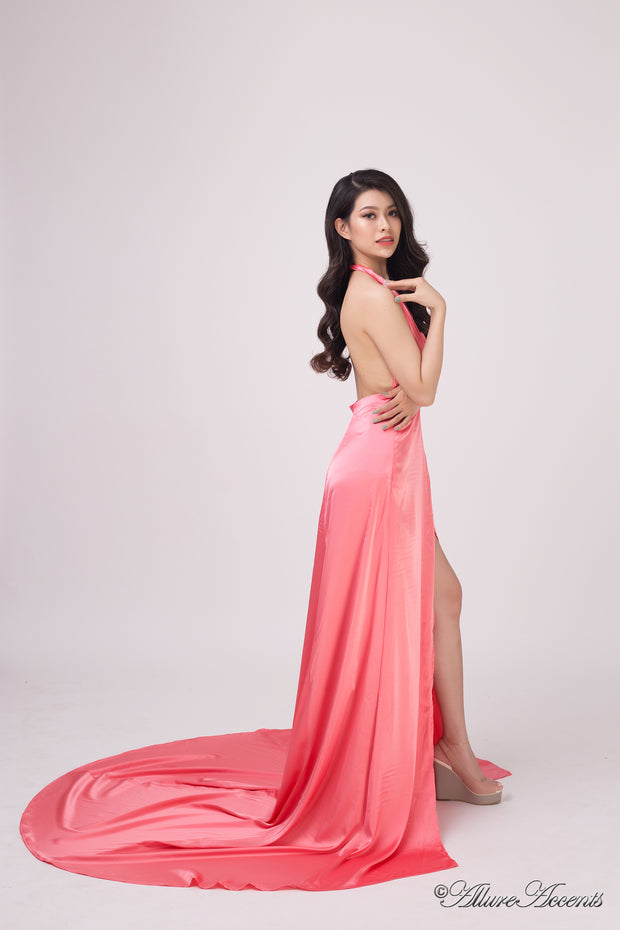 Woman wearing a red silk satin halter neck gown with a high leg slit.