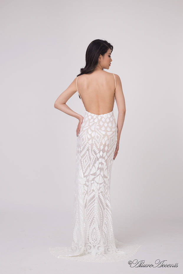 Woman showing the long white sequined dress is backless.