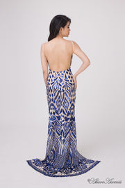 Woman showing the long blue sequined dress is backless.