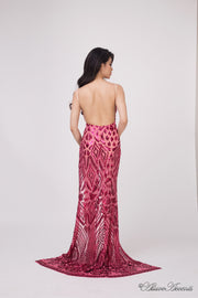 Woman showing the long red sequined dress is backless.