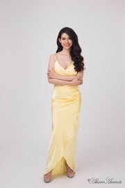 Woman wearing a long yellow colored silk dress with ruching.