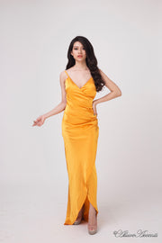 Woman wearing a long orange colored silk dress with ruching.