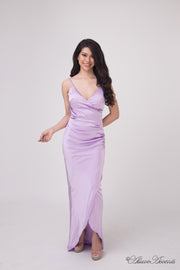 Woman wearing a long lavender colored silk dress with ruching.