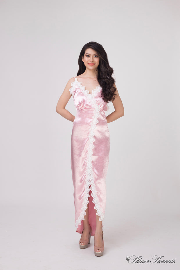 Woman wearing a light pink satin midi dress, low-cut back with lace details