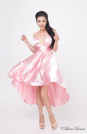 Woman wearing summer pink satin party dress, hi-low style with chest paddings