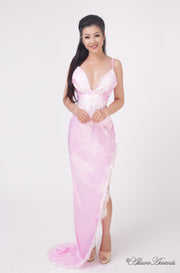 woman wearing a sexy long high slit pink satin dress with lace details 