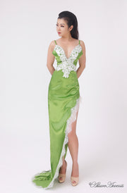 woman wearing a sexy long high slit green satin dress with lace details 