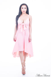 Woman is wearing a light pink hi-low dress, sexy summer sleeveless casual dress with front adjustable tie bow