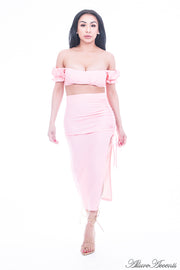 Woman is wearing a light pink 2 pieces summer party set, ruffle top and ruche tie skirt 