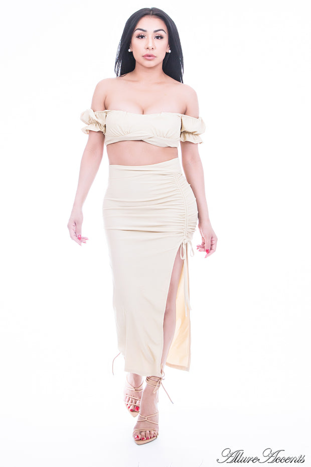 Woman is wearing a beige 2 pieces summer party set, ruffle top and ruche tie skirt 