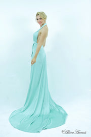 Woman showing a mint silk satin halter neck gown is backless.