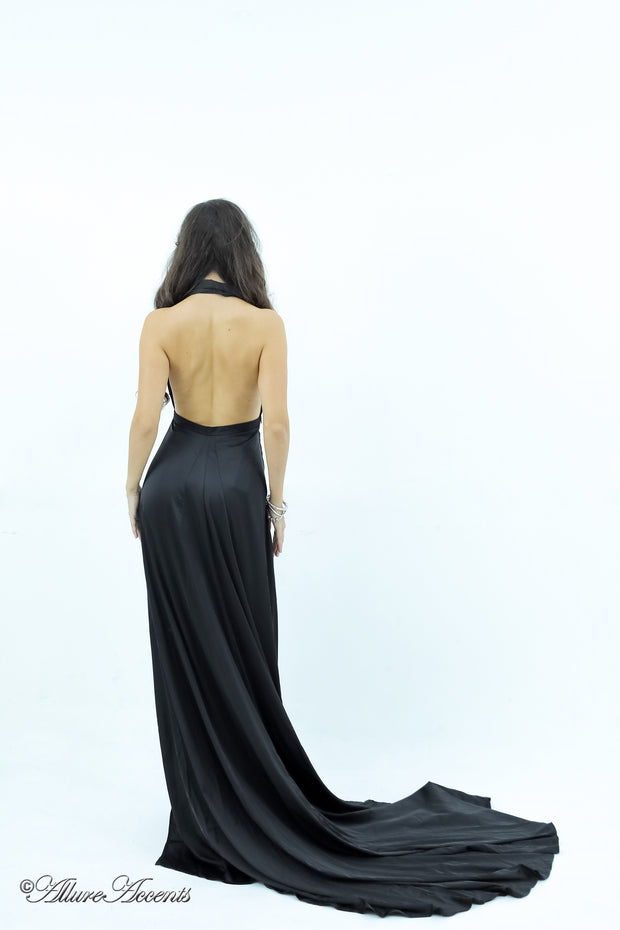 Woman showing a black silk satin halter neck gown is backless.