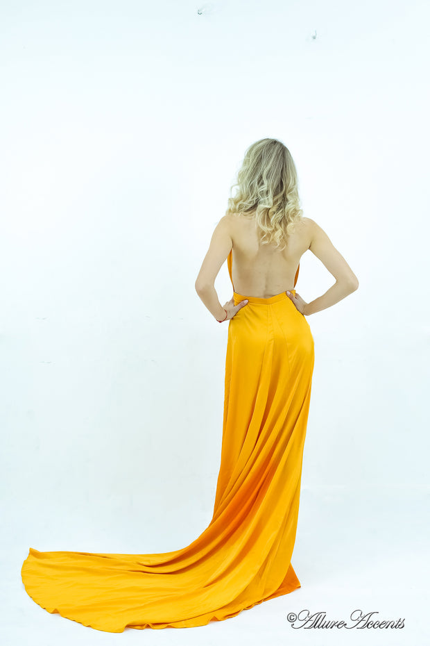 Woman showing a yellow silk satin halter neck gown is backless.