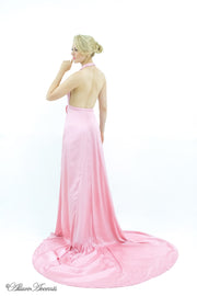 Woman showing a baby pink silk satin halter neck gown is backless.