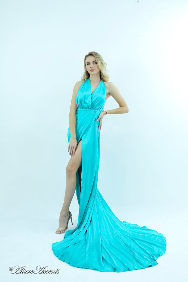 Woman wearing a tiffany blue silk satin, halter neck gown with a high leg slit.