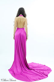 Woman showing a fuchsia silk satin halter neck gown is backless.