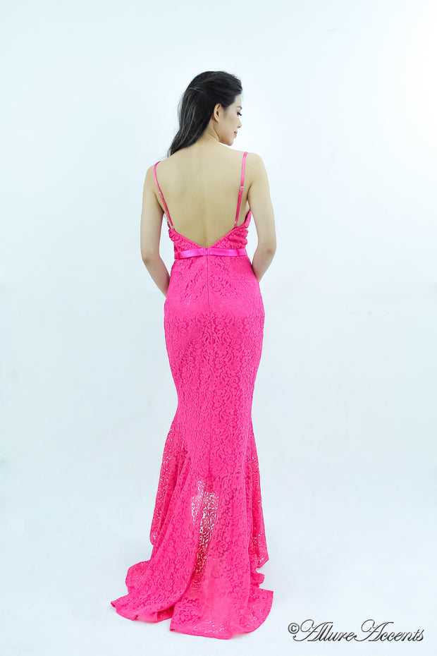 Woman showing a barbie pink high-low floral lace dress has an open back..