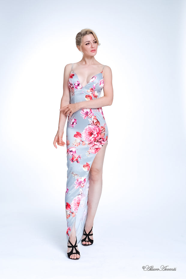 Woman wearing a pink summer satin floral party maxi, low cut back and has sexy side slit 
