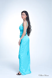 Woman wearing a long sapphire blue colored silk dress with ruching.