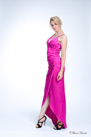 Woman wearing a long fuchsia colored silk dress with ruching.