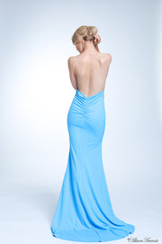 Woman showing her long baby blue gown is backless and has ruching on the butt. 