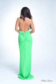 Woman showing her long lime green gown is backless and has ruching on the butt. 