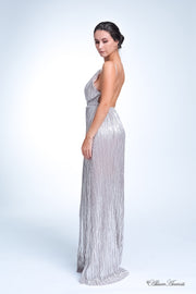 Woman wearing a silver colored maxi length slip dress with a deep v neck.