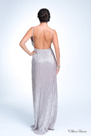 Woman wearing a silver long maxi length slip dress showing it has a low back cut.