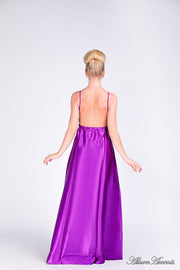 Woman wearing a plum purple long satin dress showing it has a low back.