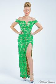 Woman wearing a green lace dress with a front slit. 