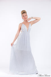 Woman wearing a white colored maxi length slip dress with a deep v neck.